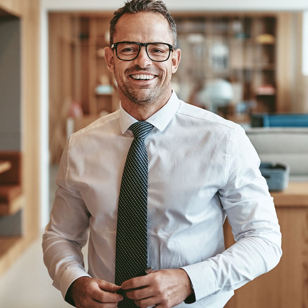 smiling-mature-businessman-standing-alone-in-an-of-GQBLE64.jpg